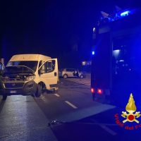 Veicolo parcheggiato su strada notturna, intervento delle autorità con luci blu: scena d’emergenza con auto della polizia/ambulanza sullo sfondo.
