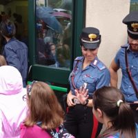 Due ufficiali in uniforme militare in mezzo alla folla di persone, una stretta di mano al centro tra gli spettatori, background di entrata verde