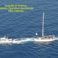 Nao al largo, motoscafo spinge un’imbarcazione a vela su acque azzurre: intervento della Guardia di Finanza, Dipartimento Operativo Aeronavale di Vibo Valentia.