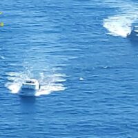 Due moto d’acqua sfrecciano su acque azzurre, creando schizzi bianchi durante una giornata luminosa.