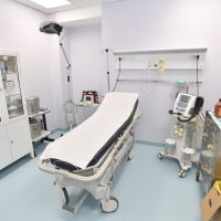 Sala operatoria luminosa con lettino chirurgico, monitor e attrezzature mediche in ordine per interventi ambulatori.