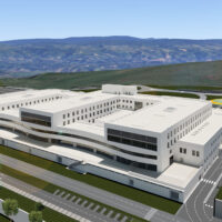 Complesso moderno bianco su terreni collinari, edifici a piani con grandi finestre, strade e verde circostante