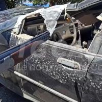 Automobile con finestra frantumata e airbags aperte, danni gravi, incidente veicolo su strada asfaltata.