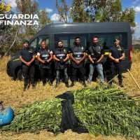 Gruppo di agenti in tenuta antincendio accanto a un furgone, in campagna: messaggio Guardia di Finanza.