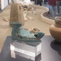 Piccolo vaso di ceramica verde turco, esposto su piedistallo in mostra di antiche ceramiche en plein air