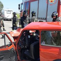 Auto incidentata con equipaggio di vigili del fuoco all’opera: soccorsi e veicoli di emergenza in primo piano.