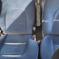 Due sedili blu di aereo o bus ben imbottiti, con cuciture visibili, aspetto pulito e leggermente usato.