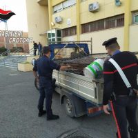 Controllo e carico di materiali su un rimorchio, due persone in uniforme vicino ad un furgone in un cortile aziendale.