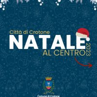 Logo natalizio con testo Città di Crtone Natale al Centro 2023 e stemma comunale sullo sfondo blu decorato con motifs festivi.