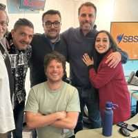 Gruppo di sei persone in ufficio sorridenti, alcuni abbracciati, atmosfera amichevole e collaborativa.