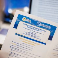 Documento ufficiale in primo piano, testo in italiano su sfondo blu e bianco, simboli e loghi istituzionali visibili.