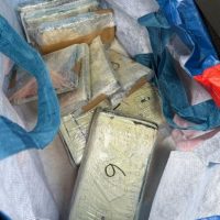 Banco di saponi profumati e saponette avvolte in carta, in una borsa di stoffa colorata.
