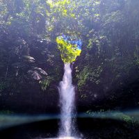 Cascata centrale in una gola verdeggiante, brillio d'acqua tra rocce, atmosfera fresca e selvaggia.