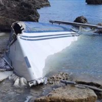 Vasca termale o piscina rocciosa allineata al mare, acque turchesi, riflessi azzurri e massi naturali sullo sfondo.