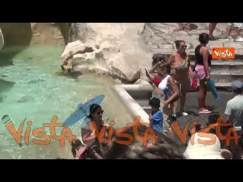 Caldo a Roma, turisti cercano refrigerio alla Fontana di Trevi